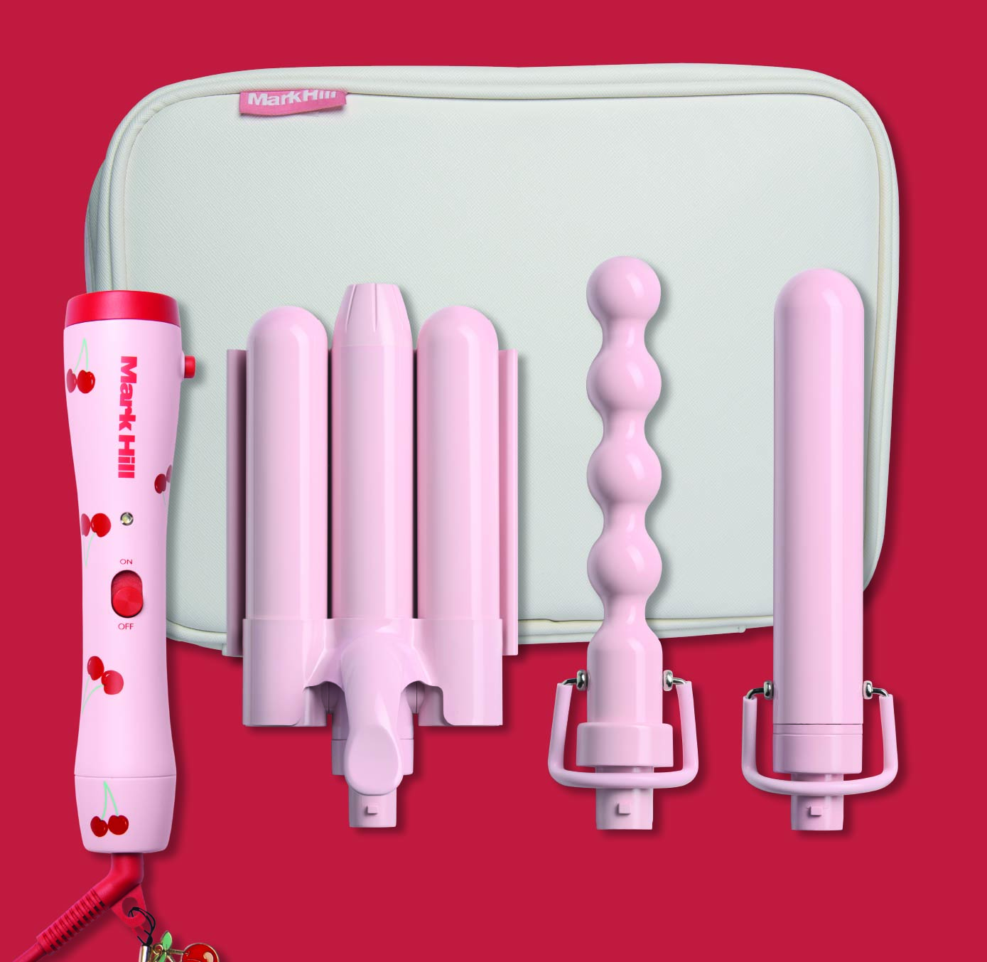 A collection of hair curlers with a red handle and various sized barrels displayed in front of a light blue bag with a cherry print mark hill