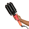 A hand holding a pink curling wand on a white background.